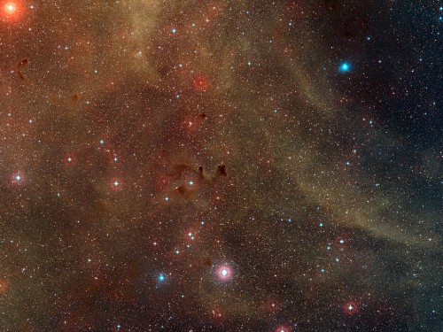 This wide-field view shows a rich region of dust clouds and star formation in the southern constellation of Vela. Close to the center of the picture the jets of the Herbig-Haro object HH 46/47 can be seen emerging from a dark cloud. Courtesy of the European Southern Observatory.