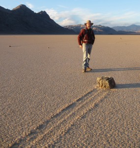 Dr. Richard Norris stands next to one of the sailing stones on Racetrack Playa. The stones only move under the right combination of conditions – thin panels of ice pushing against them as they flow in the direction of the wind. Image courtesy of Richard Norris 