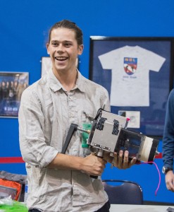 Meyer holds the Trigger Actuated Rock Sampler (TARS), which was created to chip off and collect asteroid samples for transportation to Earth from Space. TARS is a project of the Yale Drop Team. Image courtesy of Greg Meyer.