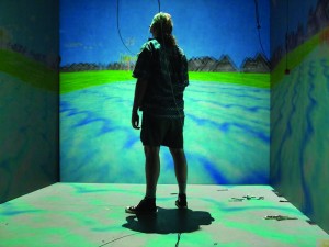 Here, a girl manipulates a cave automatic virtual environment (CAVE). In CAVE, the user resides in a room-sized cube, in which the environment is projected onto three to six of the walls. Image courtesy of Wikipedia.