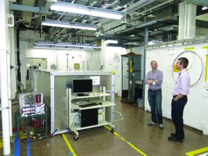 Yale postdoctoral researcher Thomas Langford and PROSPECT collaborator Nathaniel Bowden from Livermore National Laboratory with the PROSPECT test detector (metal box on left) performing test measurements at the High Flux Isotope Reactor. Image courtesy of Karsten Heeger.